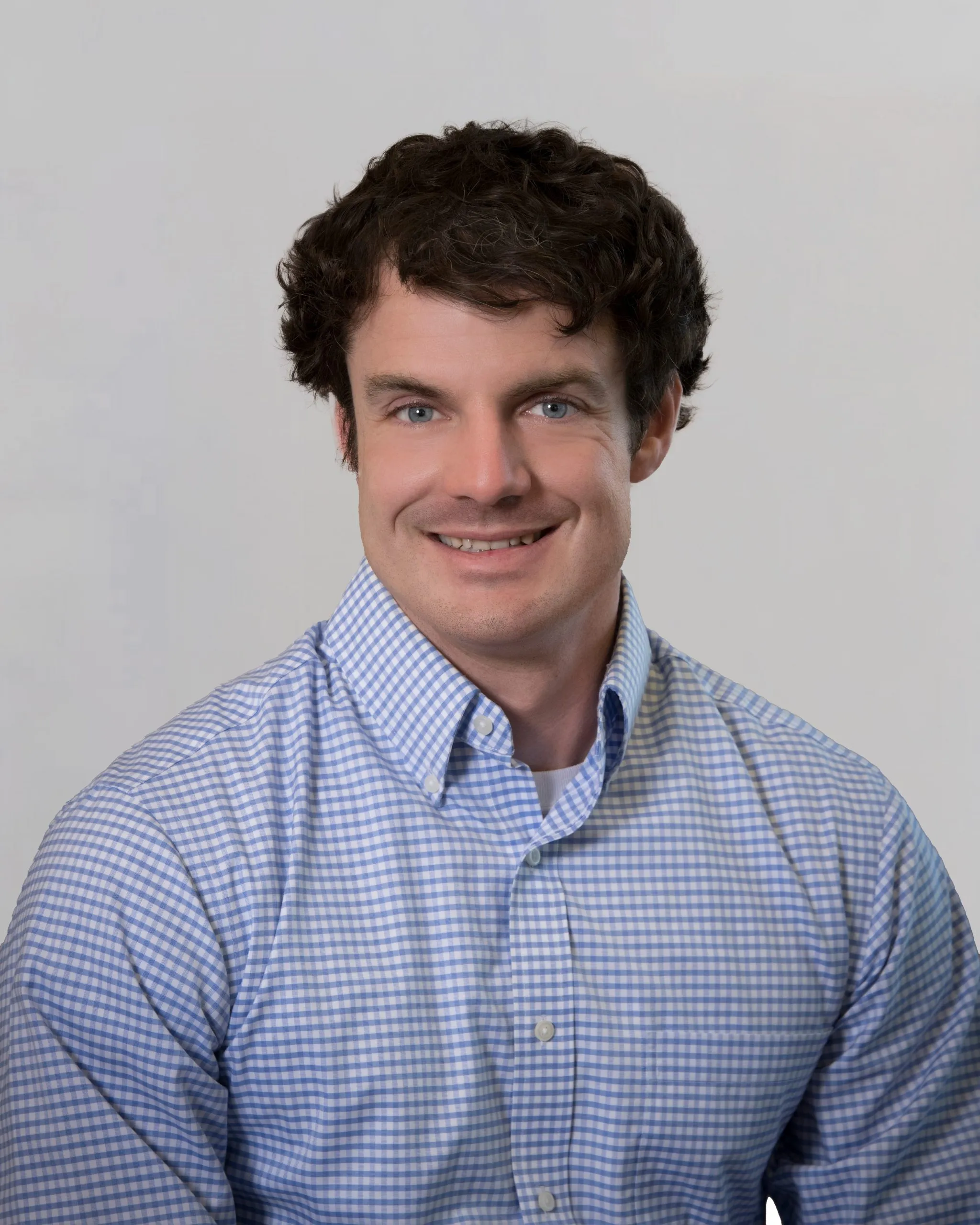 Man smiling at the camera. This is a headshot of Josh Buschling.